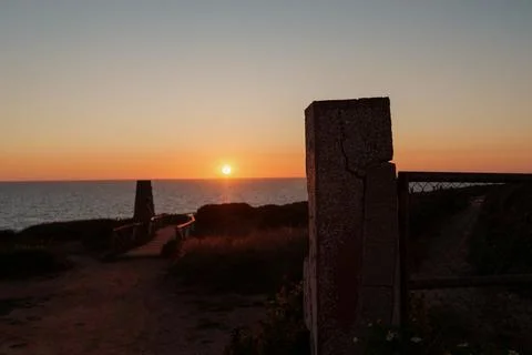 Sun setting over the sea, creating a scenic coastal view at dusk Stock Photos