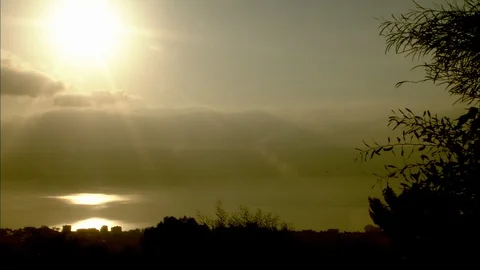 Sun setting over Sea of Galilee with clouds in sky 動画素材 95600644
