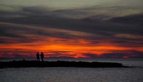 The sun is setting over the sea. Reflection. silhouettes. Stock Photos