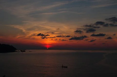 The sun is setting over the sea. Reflection. silhouettes. Waves in the sea. Stock Photos