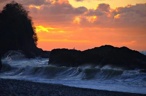 The sun is setting over the sea. Reflection. silhouettes. Waves in the sea. Stock Photos