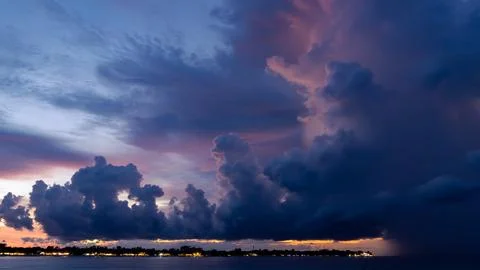 The sun is setting over a small island in the middle of the ocean Stock Photos
