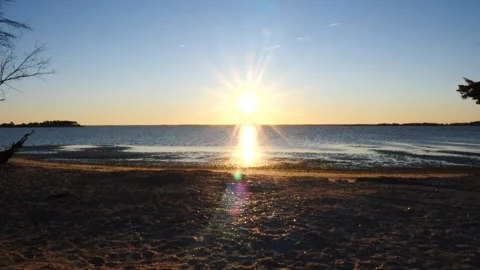 Sun Setting Over Water on Beach Stock Footage 262289592