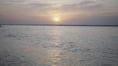 The sun is setting over the water, creating a beautiful and serene atmosphere Stock-Footage 297886738