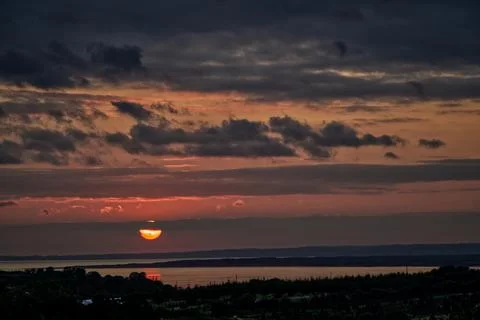 Sun setting over water Stock Photos