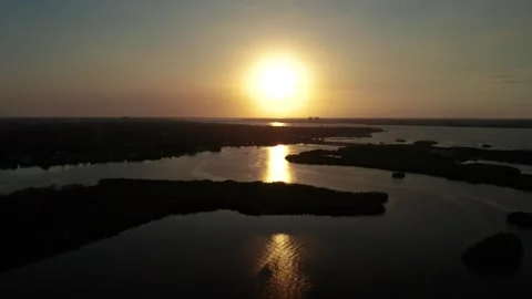 Sun Setting Over Wide Waterway with Reflective Ripples Stockbeeldmateriaal 339067097