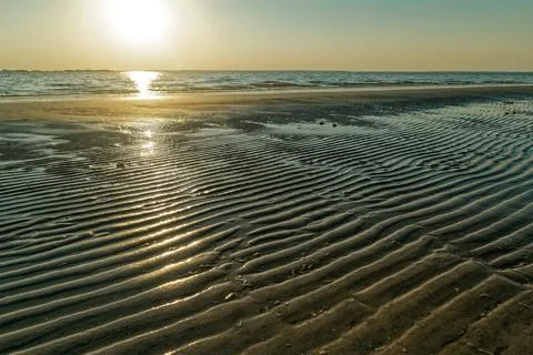Sun setting on a rippled beach Stock Photos