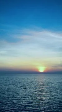 The sun is setting into the sea at sunset Stock Photos