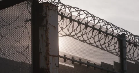 Sun setting Through Barbed Wire And Fence, Prison Border, Security Stock Footage 246984997