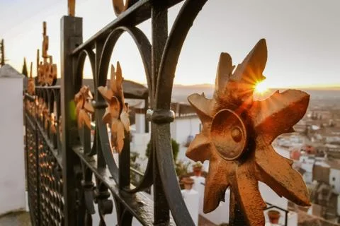 Sun setting through a railing in the old town of Granada, Spain Stock Photos
