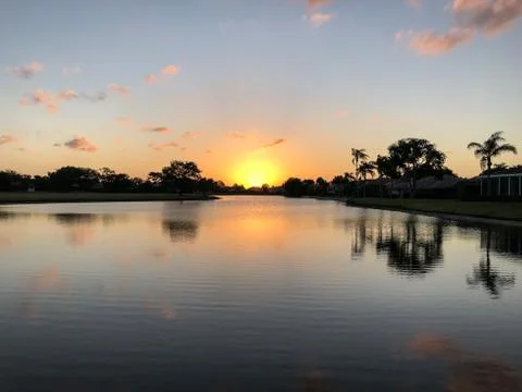 Sun setting into the water Stock Photos