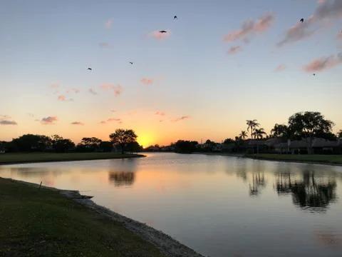 Sun setting into the water Stock Photos