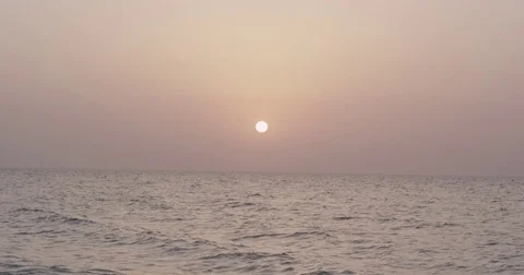 The Sun setting with waves below in slow motion Stock Footage 73253482