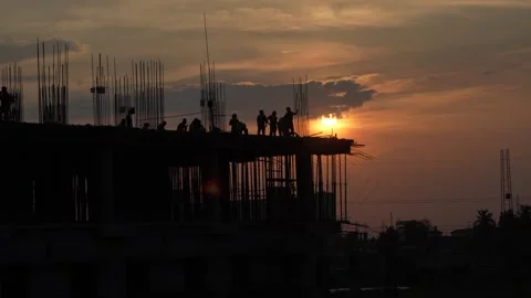 The sun is setting, yet the workers are continuing to work. Stock Footage 342699349