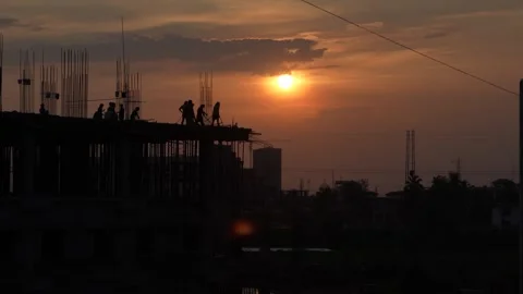 The sun is setting, yet the workers are continuing to work. Stock Footage 342703285