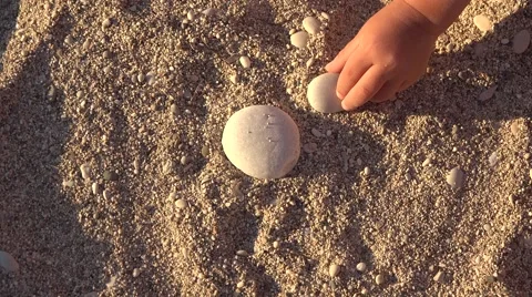 Sun shape stones building on beach made by parent and child hands 4K Stock Footage 46211586
