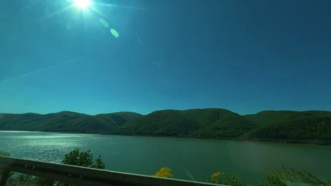 Sun shines brightly over calm lake waters. Balkan, Eastern Europe, POV Video stock 333349720