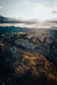 The sun shines brightly through the clouds over the mountains Stock Photos