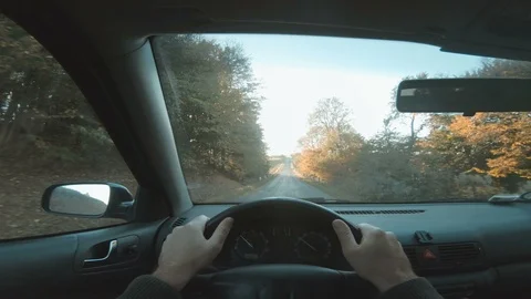 Sun shines as driver holds on to steering wheel while driving car Stock Footage 98058547