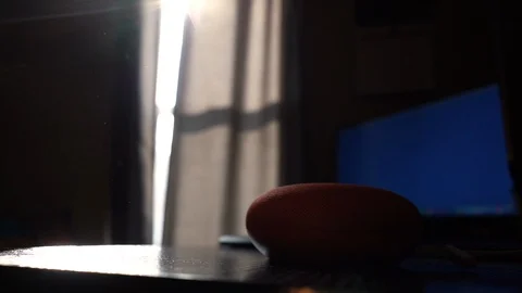 Sun Shines on Google Home Mini on Desk Stock Footage 102529156