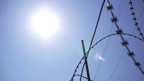 The sun shines through the barbed wire. Shooted in motion. Video stock 79622734