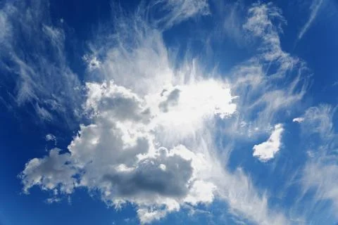 Sun shines through the clouds in the blue sky Stock Photos