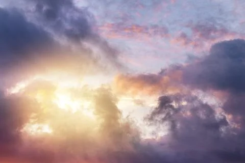 The sun shines through the clouds. Dark dramatic clouds. Sunset with copy space Stock Photos