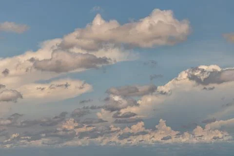 The sun shines through the clouds in the sky.  The shape of the clouds evokes Foto stock