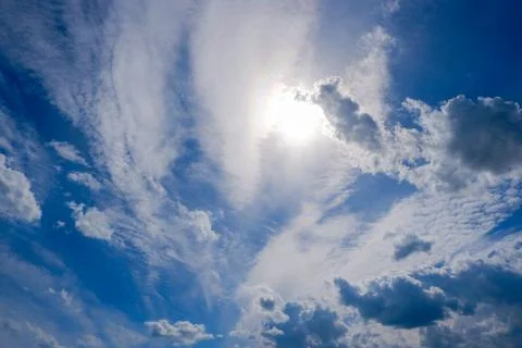 The sun shines through the clouds in sunny summer weather Stock Photos