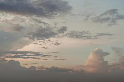 The sun shines through the clouds in the sunset sky with dramatic light. The Stock Photos