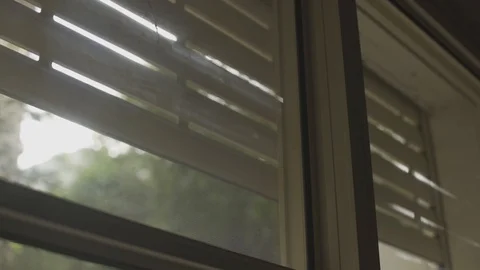 Sun shines through cracks of electric blinds being closed Stock Footage 101460377