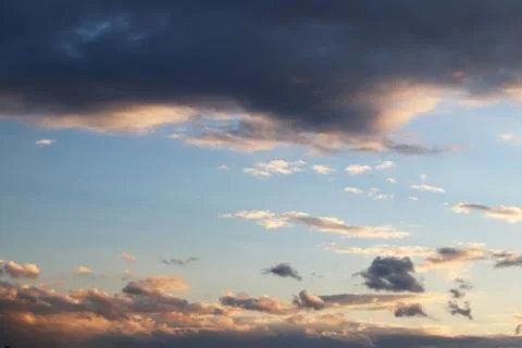The sun shines through the cumulus clouds in the blue sky. Background and tex Stock Photos