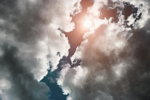 Sun shines through storm clouds, dramatic sky scenery with thunderclouds up.. Stock Photos
