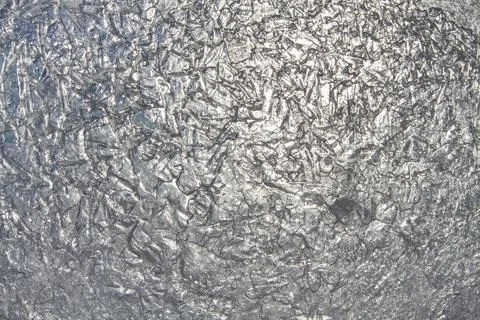 The sun shines through the thin bumpy ice Foto stock