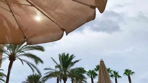 The sun shines through the umbrella to the sunbed lying on the beach Stock Footage 116013531