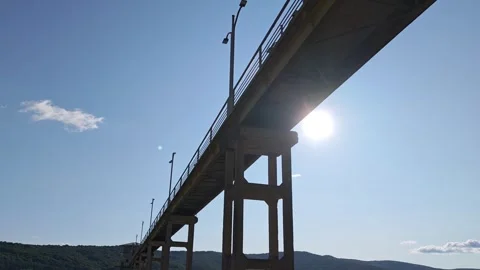 Sun shining behind bridge over lake on sunny day Vidéo 312122726