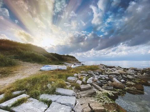 The sun shining from behind the hill on the beach Stock Photos