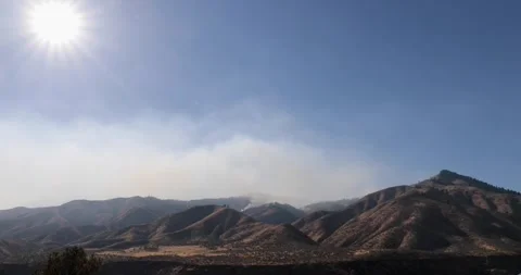 The sun is shining brightly on the mountains, creating a beautiful Stock Footage 329943479