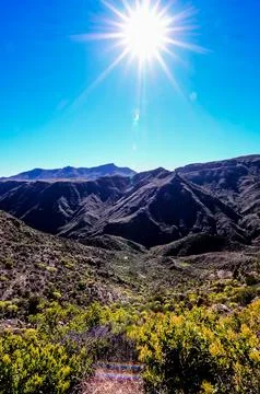The sun is shining brightly on the mountains, creating a beautiful Stock Photos