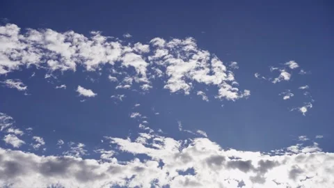 Sun shining brightly through white clouds in blue sky Stock Footage 329751616