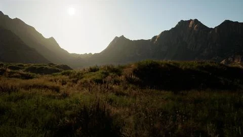 The sun is shining over a mountain range. mountain sunset Illustrazione stock