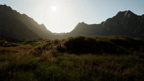 The sun is shining over a mountain range. mountain sunset Ilustração Stock