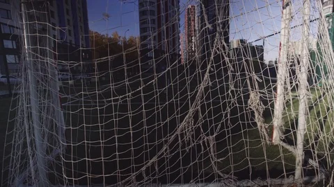 Sun is shining though soccer gates or net at the abandoned empty football field Stock Footage 99117804