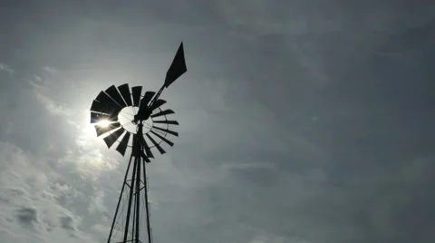 The sun shining through the blades of a ranch windmill Stock Footage 69174076
