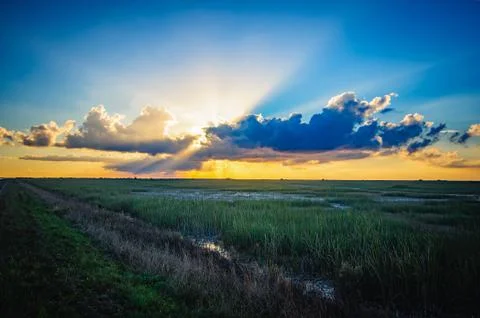 Sun shining through the blue clouds after the rain on a warm autumn day Fotos de archivo