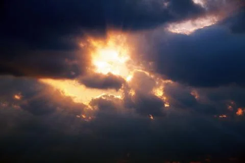 The sun shining through the clouds in the cloudy sky and a strong beam of light Stockfoto's