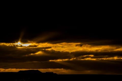 The sun is shining through the clouds, creating a beautiful and serene scene Stock Photos