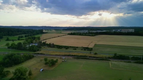 Sun shining through clouds on crop fields Stock Footage 245706577