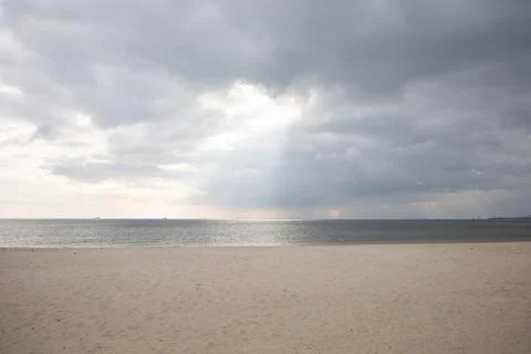 Sun shining through clouds on empty beach by the Baltic sea Foto stock