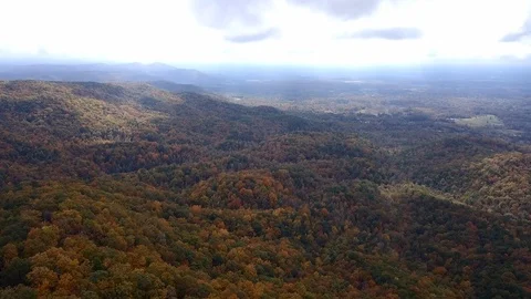 Sun shining through clouds over a fall mountain landscape 스톡 동영상 104073547